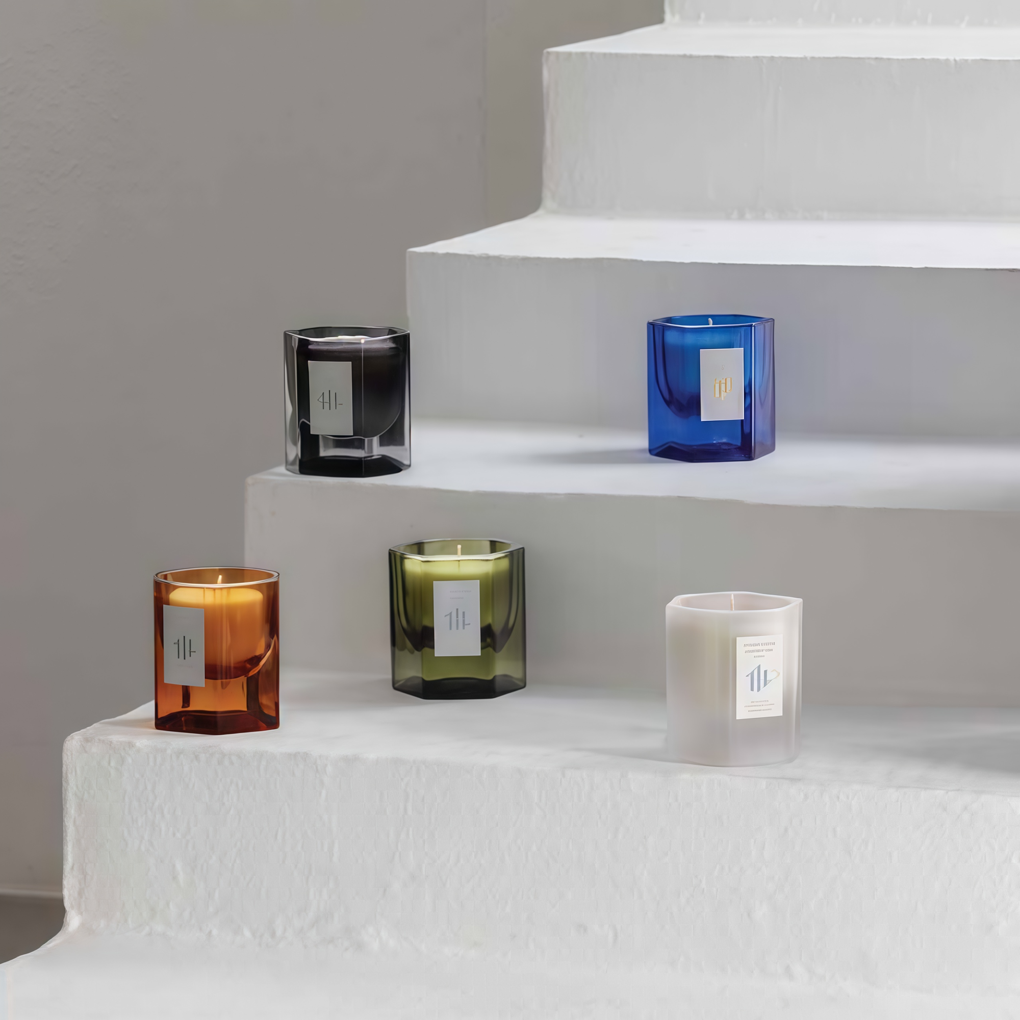 HAZE AMBIENCE glass candle collection in five colorways on white steps