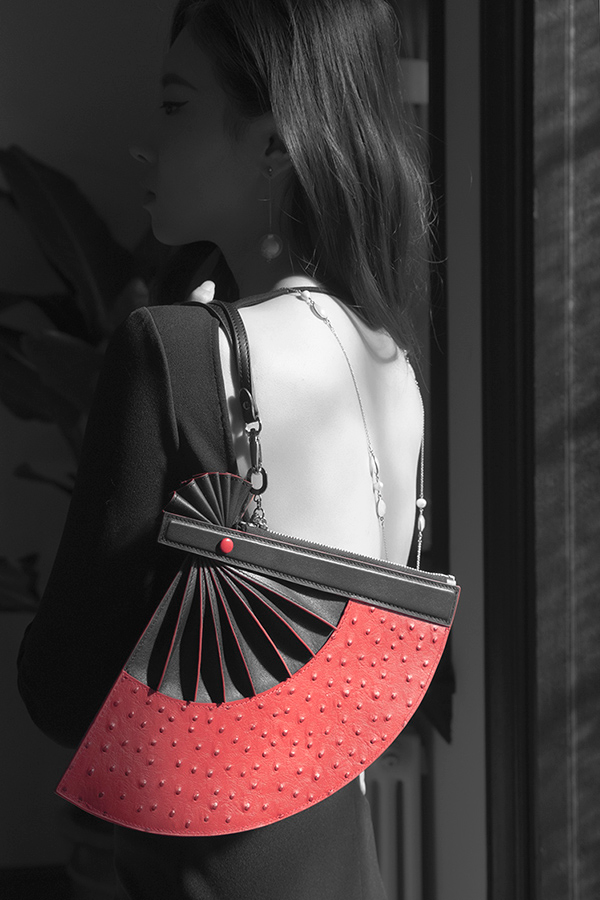 Model wearing LAOGUI Unfolding Grace Clutch fan-shaped leather bag in black and red