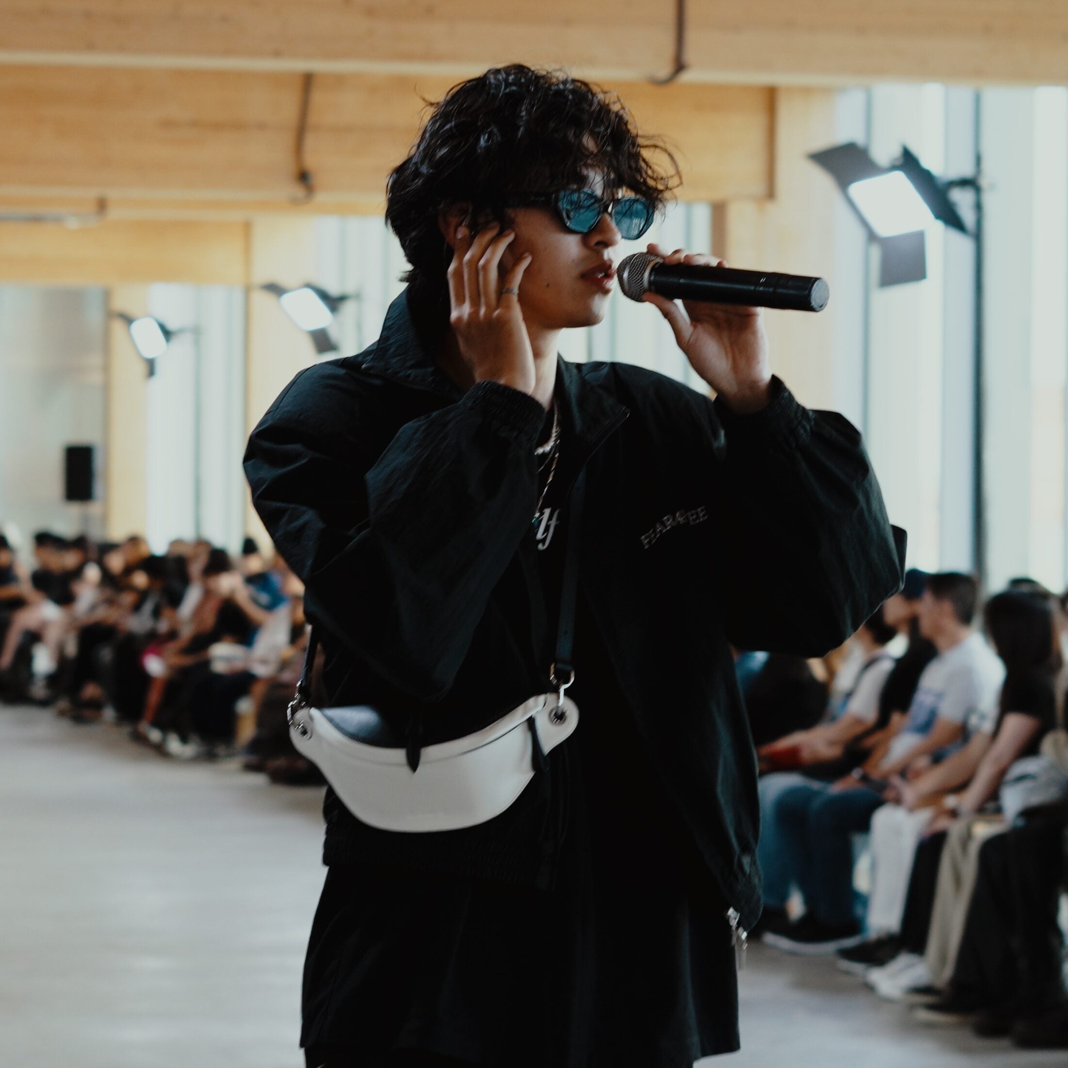 Live performer wearing HAZE sunglasses and carrying a LAOGUI bag during Fashion Art Toronto