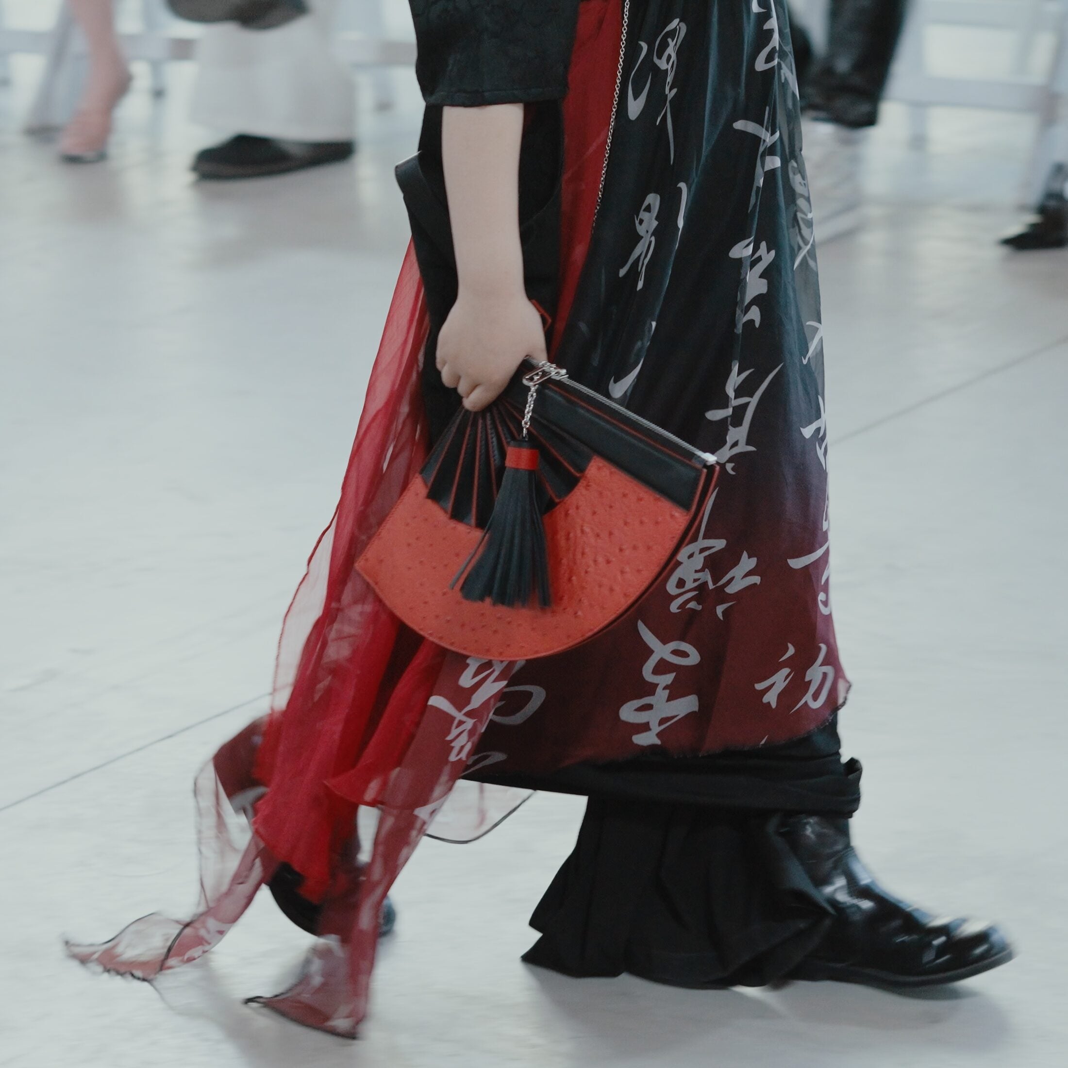 Red LAOGUI fan bag carried with black and red Chinese calligraphy styling